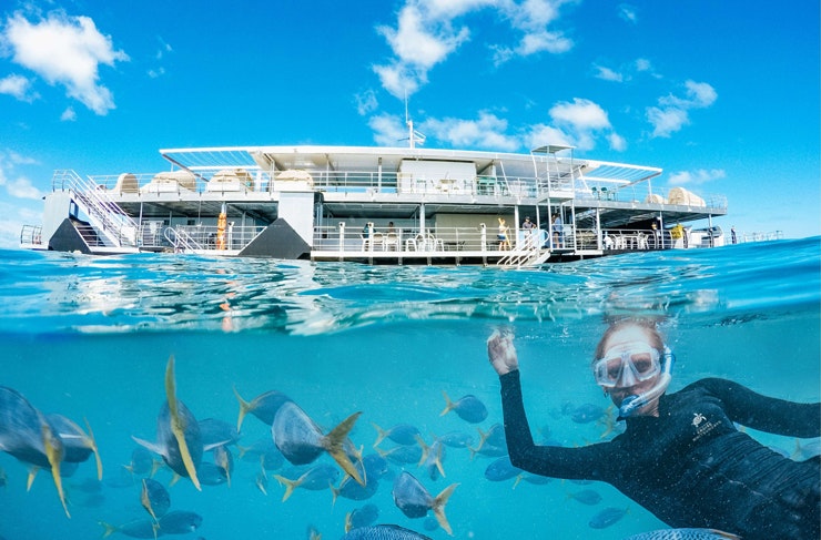 A woman snorkelling in front of the ReefSleep hotel